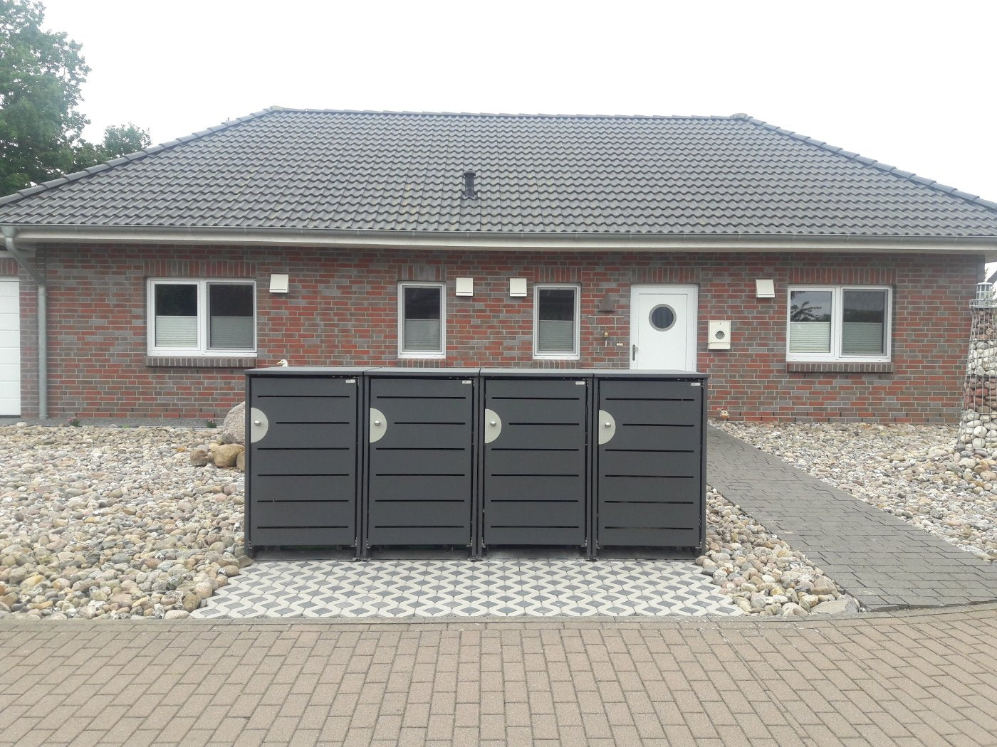 Vierfach-Anlage HALABOX Kompakt mit Türdesign vor einem Klinkerbungalow