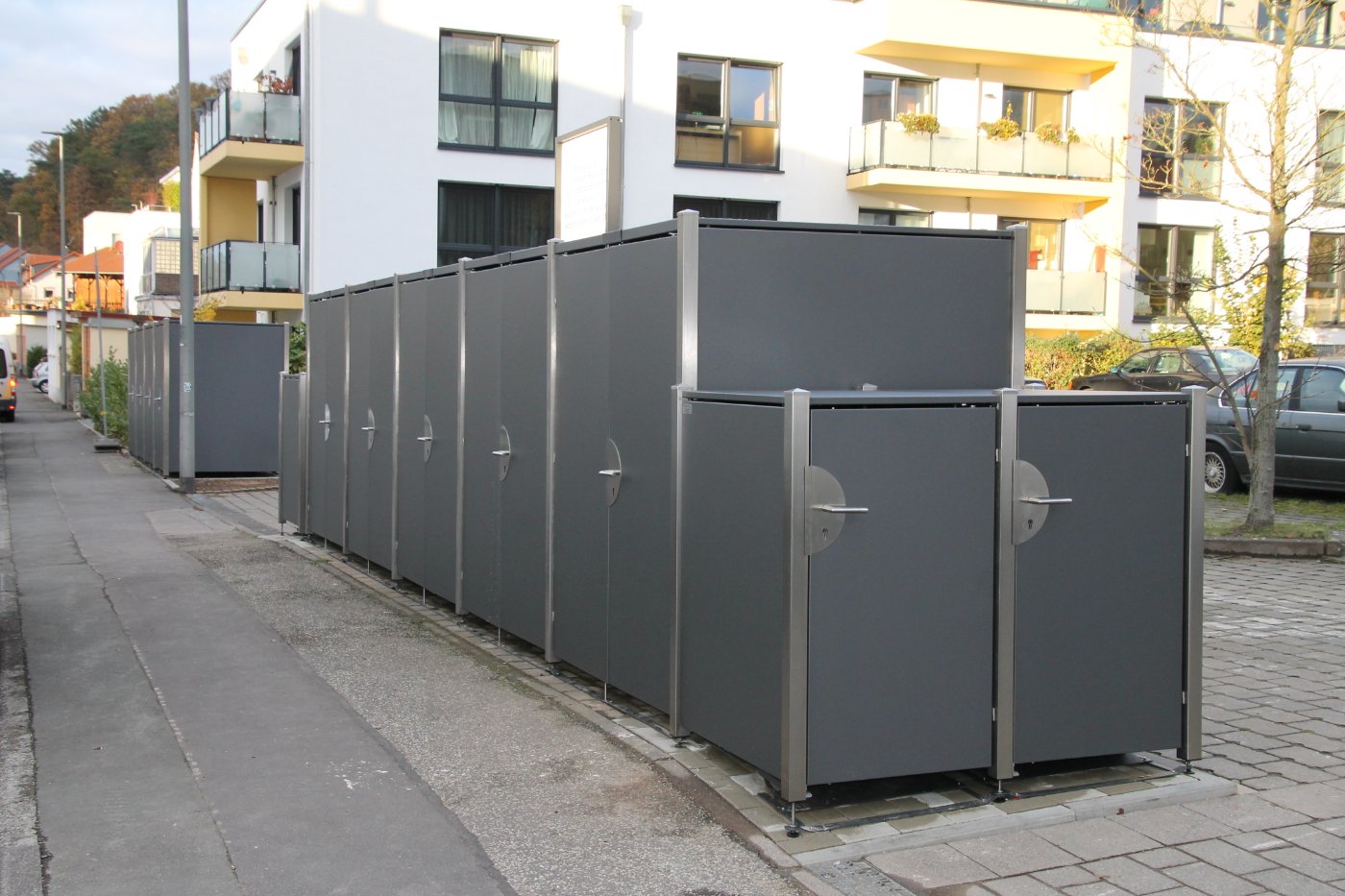 Lange Reihe HALABOX Modular entlang des Gehwegs einer Wohnanlage